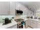 Close-up of a modern kitchen featuring stainless steel appliances, granite countertops, and grey cabinets at 13951 Wood Duck Cir, Lakewood Ranch, FL 34202