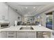 Modern kitchen with a granite island, stainless steel dishwasher and sink, and grey cabinets at 13951 Wood Duck Cir, Lakewood Ranch, FL 34202