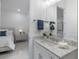 Bright bathroom with white cabinets, granite countertop, and doorway to bedroom at 15603 Derna Ter, Bradenton, FL 34211
