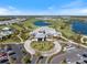 Aerial view of a grand community clubhouse surrounded by landscaped grounds, a golf course and a serene lake at 15603 Derna Ter, Bradenton, FL 34211