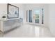Bright foyer with marble floors, striking modern art, and glass paneled front doors at 15603 Derna Ter, Bradenton, FL 34211