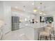 Modern white kitchen featuring stainless steel appliances and a large center island with seating at 15603 Derna Ter, Bradenton, FL 34211