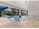 Covered outdoor living space with pool view, featuring dining and lounging areas at 15603 Derna Ter, Bradenton, FL 34211