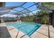 Screened-in pool with clear blue water and travertine tile, surrounded by lush landscaping at 15603 Derna Ter, Bradenton, FL 34211