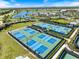 Aerial view of well-maintained tennis courts in a beautiful community with lush landscaping and nearby lake at 15603 Derna Ter, Bradenton, FL 34211
