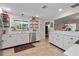 Modern kitchen featuring white shaker cabinets, stainless steel appliances, and open shelving at 324 Bernard Ave, Sarasota, FL 34243