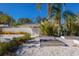 Tropical backyard with raised garden beds and a whitewashed wall at 3913 Chapel Dr, Sarasota, FL 34234