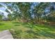 Large backyard with lush lawn, mature trees, and wooden fence at 4132 Carriage Cir # 12, Sarasota, FL 34241