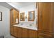 Double vanity bathroom with wood cabinets and large mirrors at 4132 Carriage Cir # 12, Sarasota, FL 34241