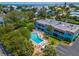 Aerial view of a condo building with a pool and parking area, surrounded by lush landscaping at 4307 Gulf Dr # 103, Holmes Beach, FL 34217