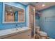 Fresh blue bathroom with mirrored cabinet, white vanity, and ceramic toilet at 4307 Gulf Dr # 103, Holmes Beach, FL 34217