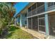 Building exterior showcasing a well-maintained lawn and screened patio at 4307 Gulf Dr # 103, Holmes Beach, FL 34217