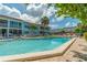Community pool with lounge chairs surrounded by lush, tropical landscaping at 4307 Gulf Dr # 103, Holmes Beach, FL 34217