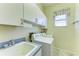 Convenient laundry room with cabinets, sink, and washer/dryer at 464 Fairway Isles Dr, Venice, FL 34285