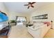 Spacious living room featuring a sectional sofa, large TV, and a ceiling fan at 7829 Pine Trace Dr, Sarasota, FL 34243