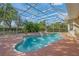 Relaxing kidney-shaped pool with a screened enclosure and brick coping at 8356 Mareva Ln, Sarasota, FL 34241