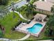 Aerial shot of community pool area with lounge chairs, lush landscaping and palm trees at 9143 Willow Brook Dr, Sarasota, FL 34238