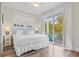 King bedroom with light wood floors and sliding door to balcony at 106 7Th S St, Bradenton Beach, FL 34217