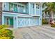 Two-story light blue home with white accents, a large garage, and a paved driveway at 106 7Th S St, Bradenton Beach, FL 34217
