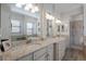 Elegant bathroom with dual vanities, a soaking tub, and a walk-in shower at 10817 Whisk Fern Dr, Venice, FL 34293