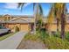 Front view of tan townhome with palm trees and driveway at 11546 52Nd E Ct, Parrish, FL 34219