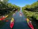 Kayakers paddle along a scenic waterway surrounded by lush mangrove tunnels on a sunny day at 1305 4Th St # 402P, Sarasota, FL 34236
