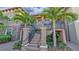 Exterior view of a two-story condo building with palm trees and a stairway at 13816 Messina Loop # 203, Bradenton, FL 34211