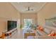 Spacious living room with a large TV, comfy sofa, and access to balcony at 13816 Messina Loop # 203, Bradenton, FL 34211