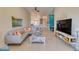 Bright living room with comfy sectional sofa, large TV, and view into kitchen at 13816 Messina Loop # 203, Bradenton, FL 34211