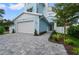 Two-story light blue house with white garage and paver driveway at 1647 Siesta Dr, Sarasota, FL 34239