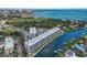 Stunning aerial view of waterfront condos with boat docks and city skyline in the background; perfect luxury living at 1703 N Tamiami Trl # 210, Sarasota, FL 34234