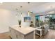 Open living space with sofa, balcony access, and a view of the kitchen at 1703 N Tamiami Trl # 210, Sarasota, FL 34234