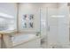 Spa-like bathroom with soaking tub, walk-in shower, and window at 1727 Waldemere St, Sarasota, FL 34239