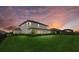 Expansive backyard at sunset featuring lush green grass and a well-maintained landscape at 17335 Polo Trl, Bradenton, FL 34211