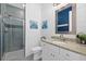Modern bathroom featuring a glass-enclosed shower, white vanity with granite countertop, and attractive wall decor at 17335 Polo Trl, Bradenton, FL 34211