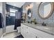 Modern bathroom with blue patterned wallpaper, granite counters, dual sinks, and a tub/shower at 17335 Polo Trl, Bradenton, FL 34211