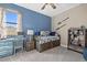 A cheerful bedroom with nautical decorations, blue walls, and a desk near the window at 17335 Polo Trl, Bradenton, FL 34211
