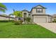 Two-story house with gray siding, three-car garage, and landscaped lawn at 17335 Polo Trl, Bradenton, FL 34211