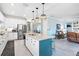 Open kitchen with granite counters, stainless appliances, white cabinets, and an island overlooking the living area at 17335 Polo Trl, Bradenton, FL 34211