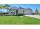 Gray house with two-car garage, landscaping, and a large front yard at 1825 Twin Rivers Trl, Parrish, FL 34219