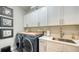 Laundry room with white cabinets, a sink, and washer/dryer at 1825 Twin Rivers Trl, Parrish, FL 34219