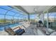 Covered patio with comfortable seating, overlooking the pool and lake at 1825 Twin Rivers Trl, Parrish, FL 34219