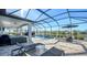 This luxurious pool area includes a screened enclosure, comfortable seating, and a built-in grill at 1825 Twin Rivers Trl, Parrish, FL 34219