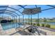 Enjoy the sunshine and lake views from this screened pool area, complete with lounge chairs and umbrella at 1825 Twin Rivers Trl, Parrish, FL 34219