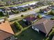 Home's backyard with a screened enclosure, surrounded by other houses and a lake at 20680 Vita Ct, Venice, FL 34293