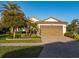 Single-story home with brown garage door and brick driveway, landscaping, and palm trees at 20680 Vita Ct, Venice, FL 34293