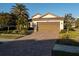 One-story house with brown garage door, brick driveway and well-manicured landscaping at 20680 Vita Ct, Venice, FL 34293