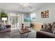 Living room featuring brown sofa, coffee table, and view into adjacent dining area at 2425 Golf Course Dr # 704, Sarasota, FL 34234