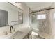 Bright bathroom featuring a marble shower with glass door and modern vanity with gold fixtures at 2435 Sumatran Way # 35, Clearwater, FL 33763