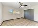 Bedroom featuring hardwood floors, closet with gray doors, ceiling fan, and a large window at 2435 Sumatran Way # 35, Clearwater, FL 33763